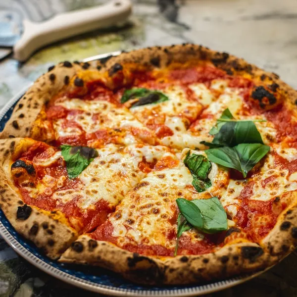 Pizza de muzzarella con albahaca fresca